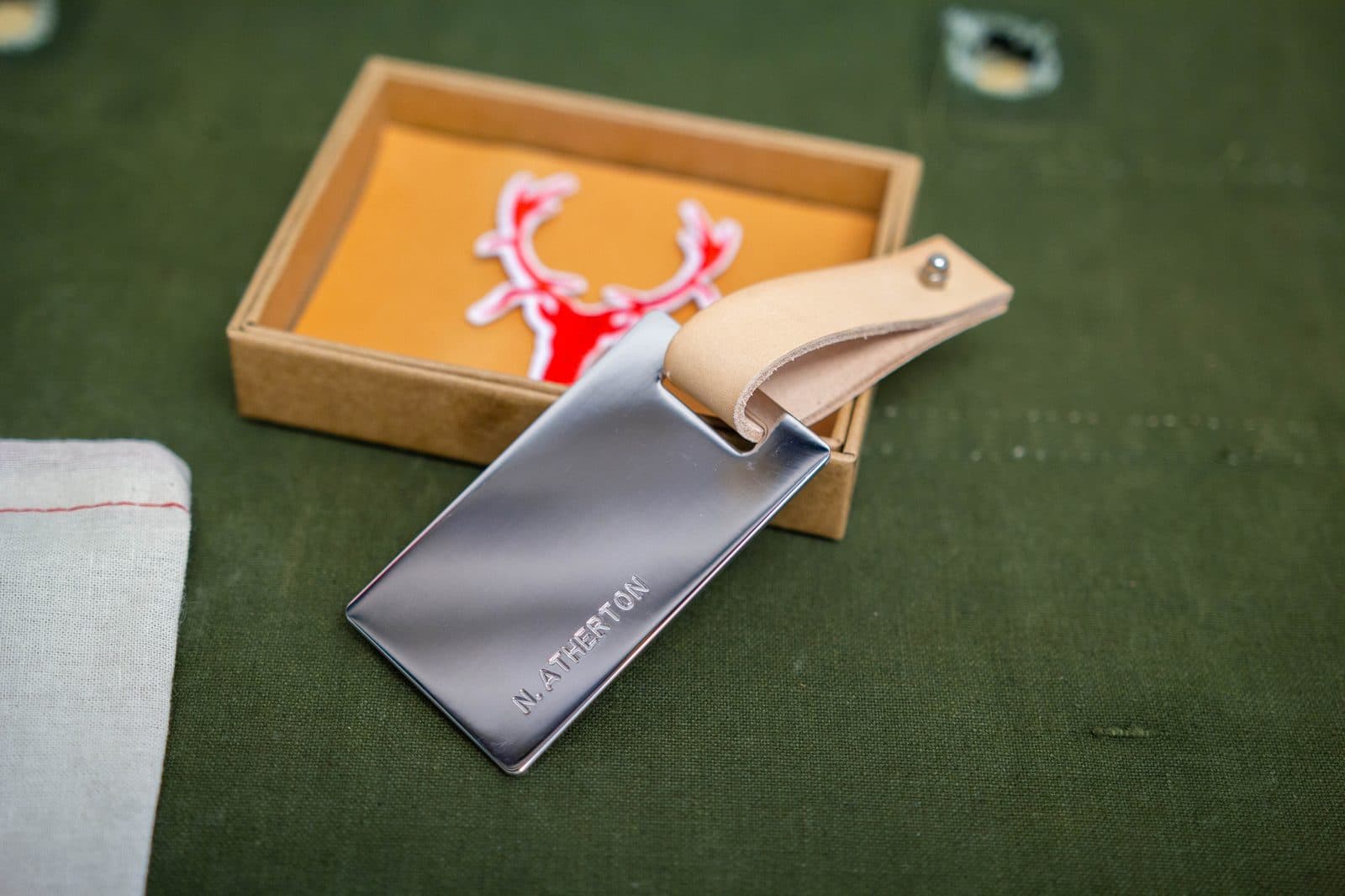 Finished luggage tag with leather strap presented alongside gift box