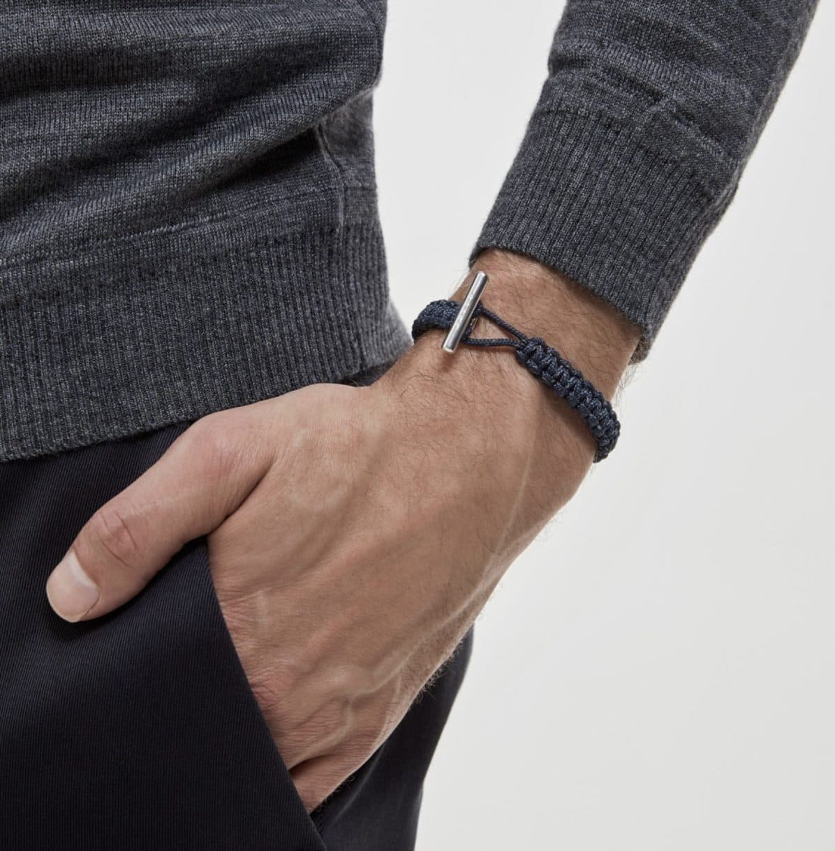 Naimakka x Volvo Cars bracelet worn on wrist — navy reflective paracord with rhodium toggle clasp